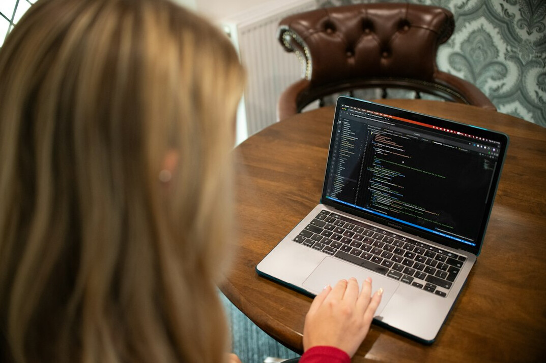 person coding on laptop