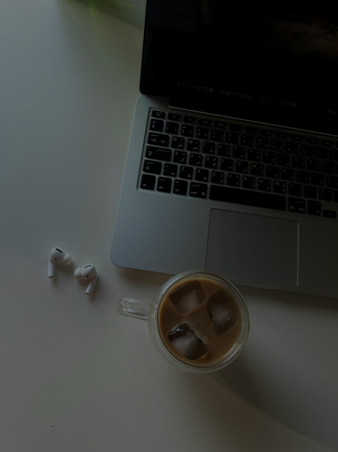 Overhead view of a desk with a laptop, notebook and coffee cup showing programming notes