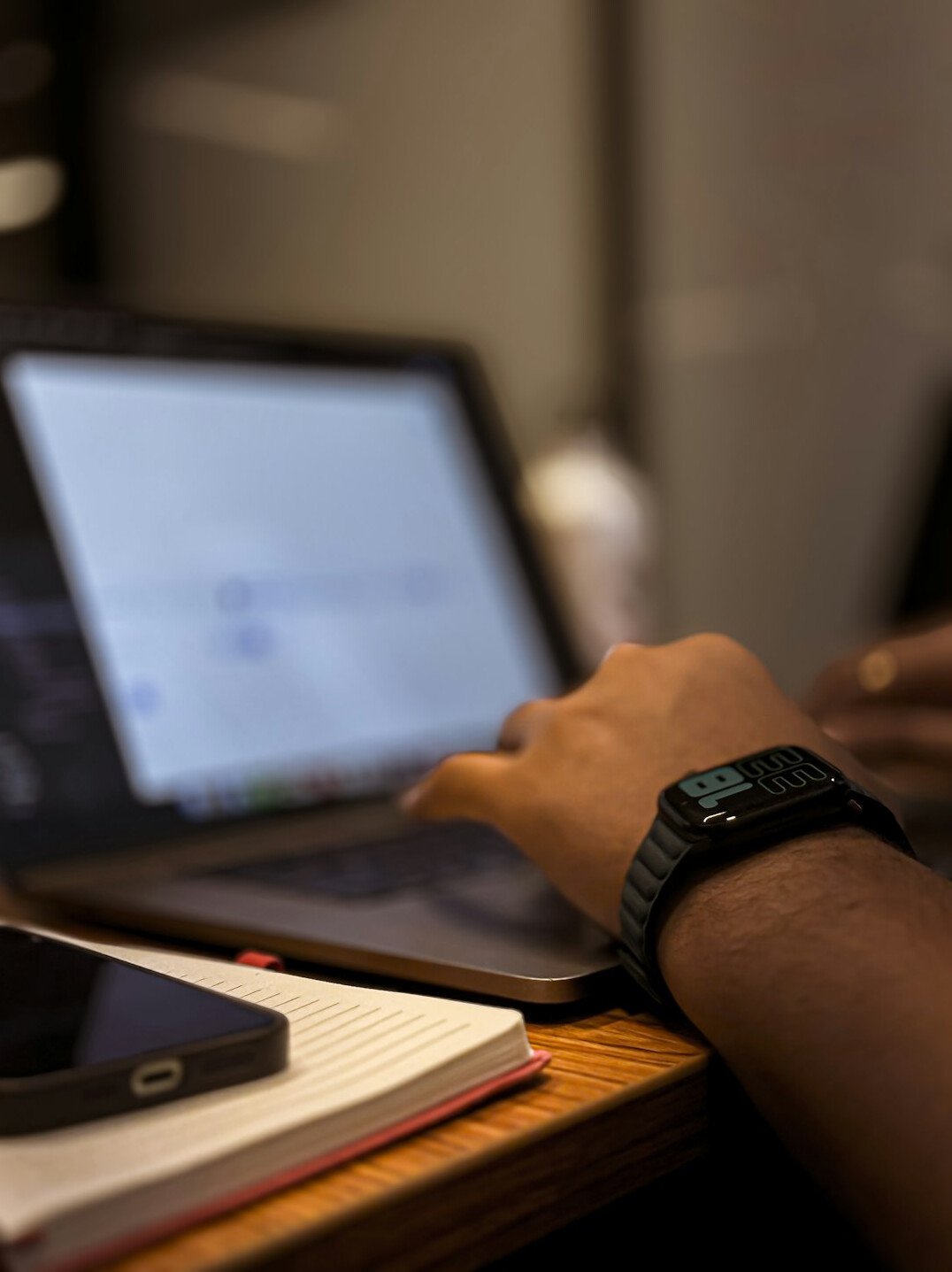 student coding on laptop with notebook