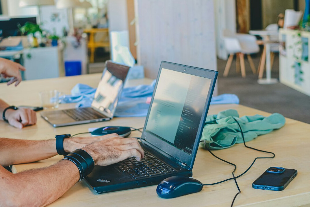 person coding on laptop at desk